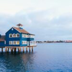 A picturesque blue building on stilts in San Diego's Seaport Village, captured at sunset.