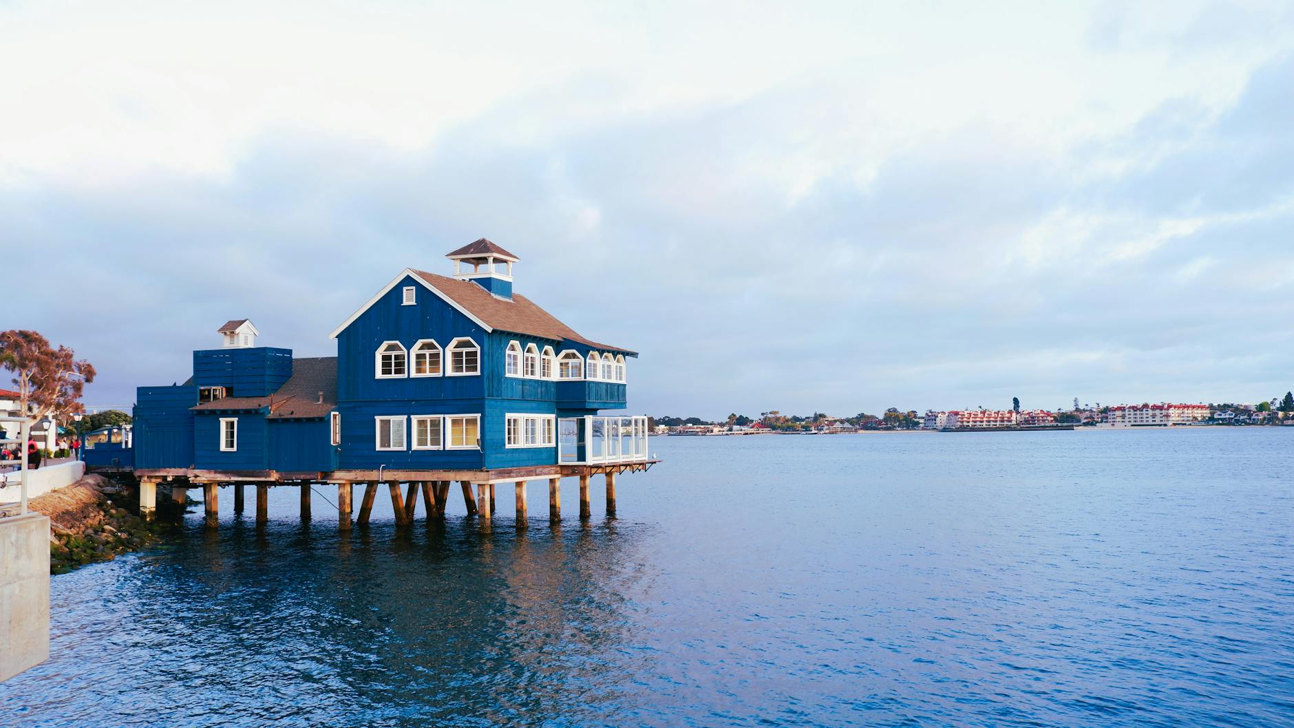 A picturesque blue building on stilts in San Diego's Seaport Village, captured at sunset.